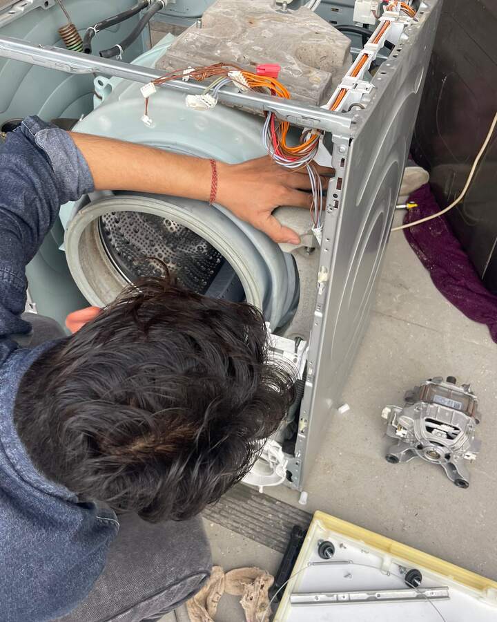 An Applicare technician repairing a washing machine drum